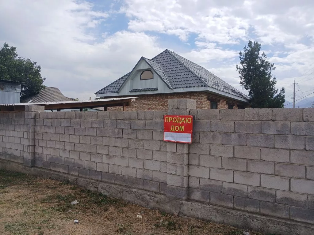 Продаётся кирпичный дом с участком и высоким забором по периметру