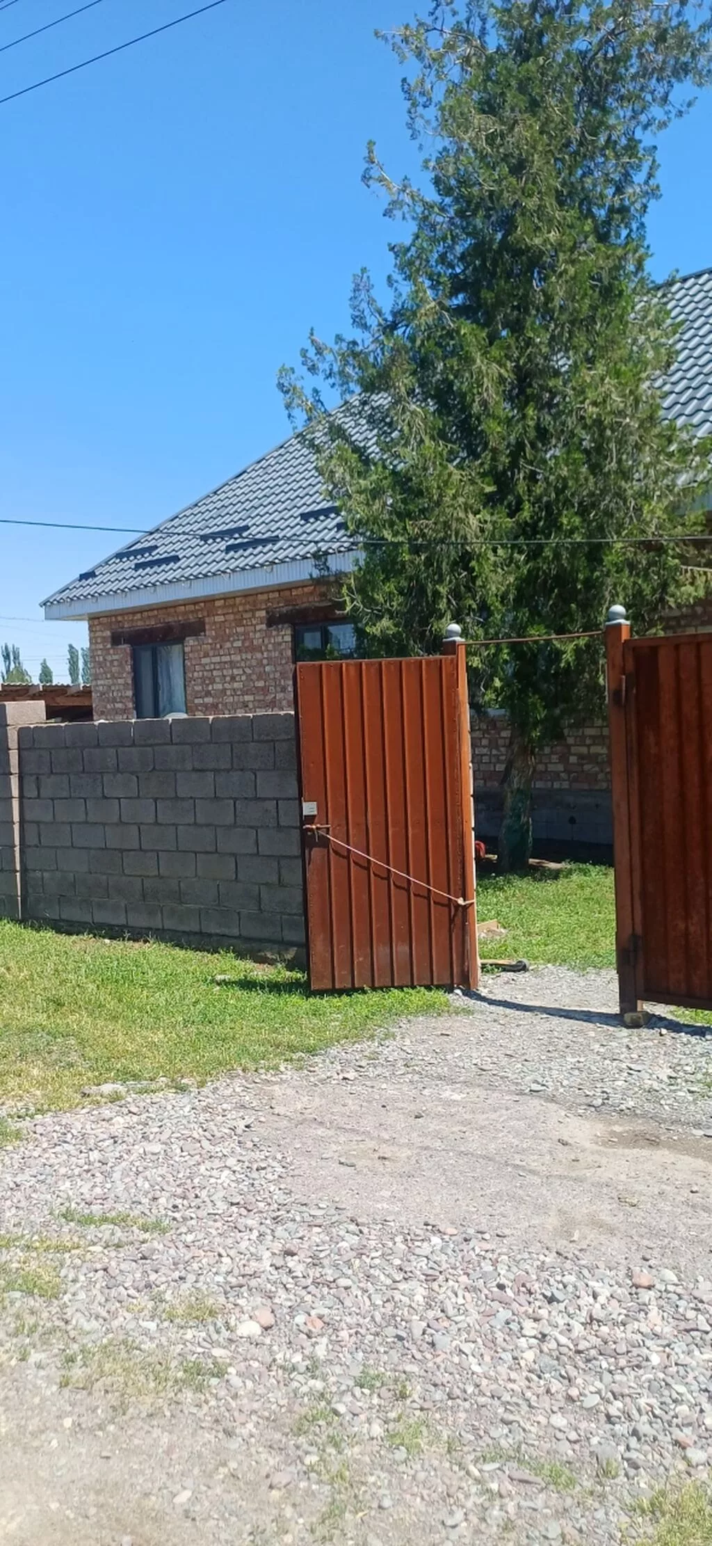 Продаётся кирпичный дом с участком и высоким забором по периметру