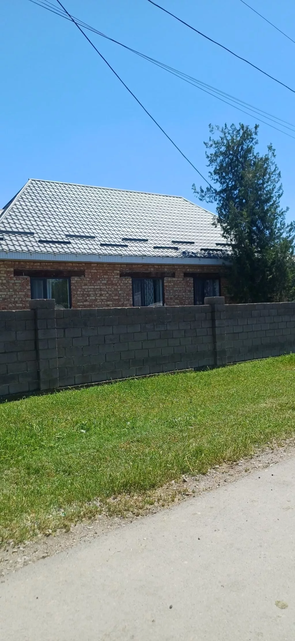 Продаётся кирпичный дом с участком и высоким забором по периметру
